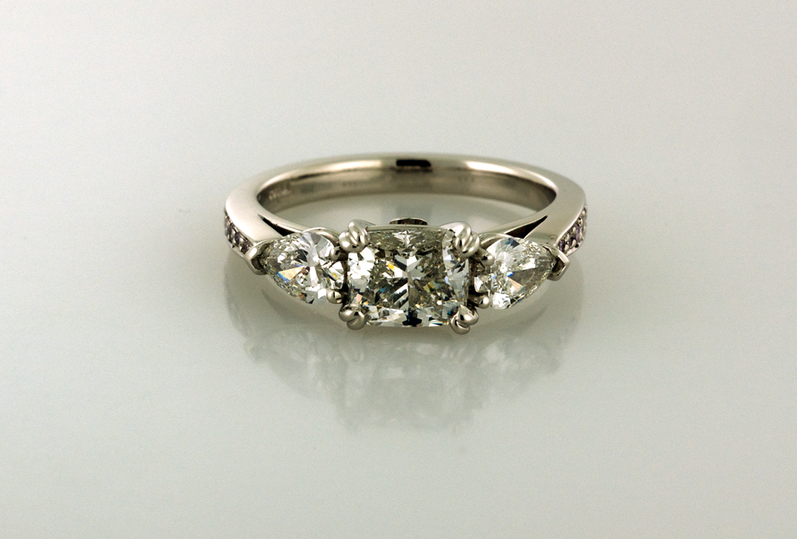 Three stone diamond platinum ring with cushion cut and pear cut side diamonds