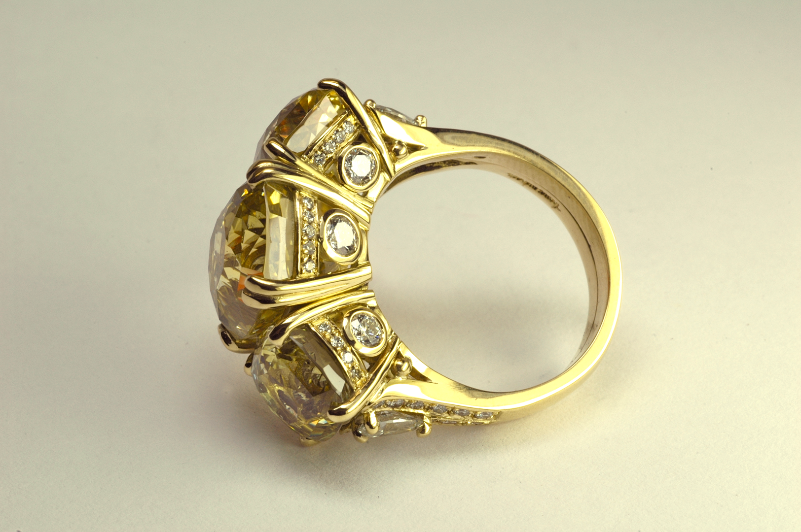 Natural Unheated Yellow Sapphire Three Stone 18KT Yellow Gold Ring, Side View Copyrighted Original by Thomas Michaels Designers, Inc. Yellow sapphire three stone ring with diamond accents