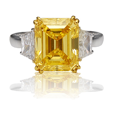 Natural yellow color diamond, emerald cut set in platinum and white baguettes