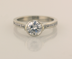Bezel set center, cathedral ring with .15ct channel set diamonds
